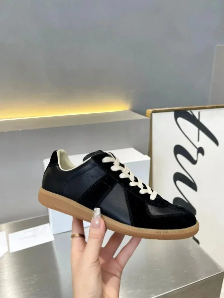 Black replica-style low-tops shown in the linked Maison Margiela catalog listing