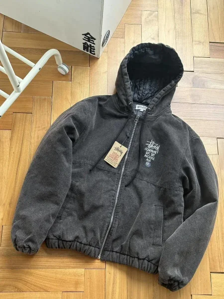 Black hooded jacket shown in the linked Stussy catalog listing